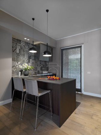 Téléchargez les photos : Intérieur d'une cuisine moderne avec un plancher en bois, au premier plan deux tabourets en arrière-plan la fenêtre française - en image libre de droit