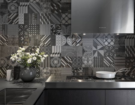 Téléchargez les photos : Plan de travail en acier dans la cuisine moderne avec cuisinière et pot de fleurs blanches - en image libre de droit