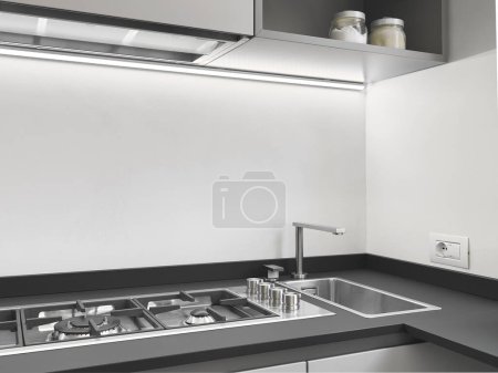 Téléchargez les photos : Gros plan d'un évier en acier et d'une cuisinère à gaz dans une cuisine moderne - en image libre de droit