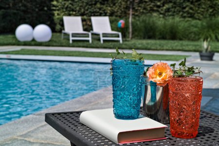 Téléchargez les photos : Verre coloré sur la table basse près de la piscine - en image libre de droit