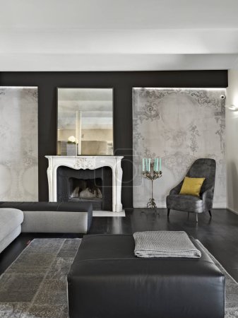 Foto de Interior de la sala de estar con papel pintado y chimenea, en primer plano hay un reposapiés - Imagen libre de derechos