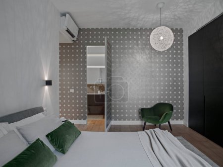 Foto de Vista interior de un dormitorio moderno con vistas al baño con un sillón el piso está hecho de piso de madera - Imagen libre de derechos