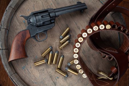 Wild-West-Pistole mit Gürtel, Holster und Munition auf Holztisch