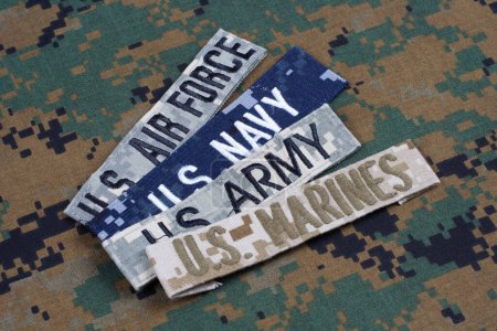 US AIR FORCE, US MARINES, US ARMY, US NAVY branch tapes on camouflage uniform background