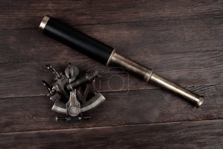 naval spyglass telescope with sextant on wooden background