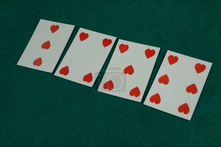 Old west era playing card on green gambling table. 3,4,5,6 of hearts.
