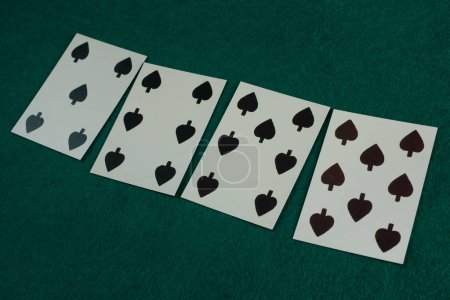 Old west era playing card on green gambling table. 5, 6, 7, 8 of spades.
