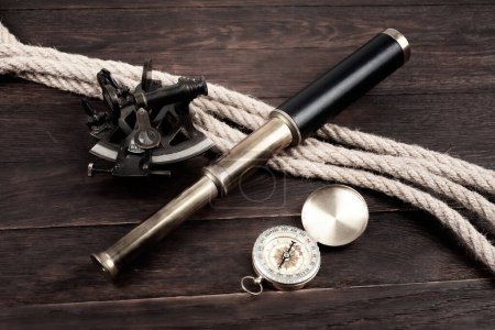 Vintage Naval Spyglass Teleskop mit Sextant und Kompass auf Holzgrund