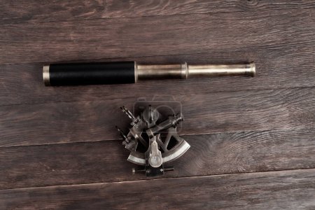 naval spyglass telescope with sextant on wooden background