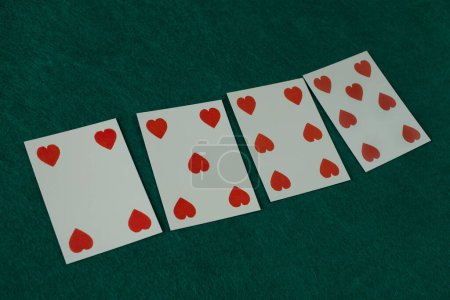 Old west era playing card on green gambling table. 4, 5, 6, 7 of hearts.