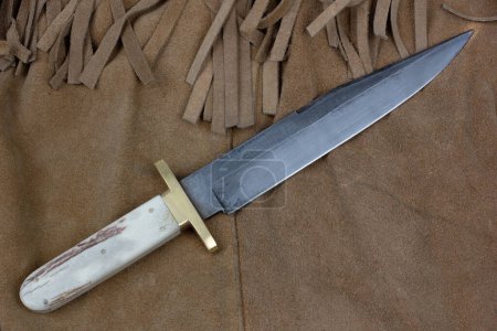 Old west bowie knife on leather jacket background