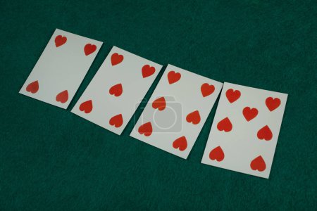 Old west era playing card on on green gambling table. 4, 5, 6, 7 of hearts.