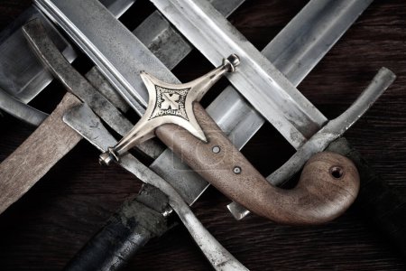 Vintage swords and sabre on wooden background.