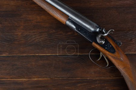 break action smooth bored double barreled side shotgun on wooden table.