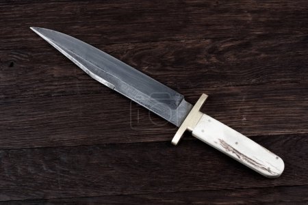 Vieux couteau bowie ouest sur fond de pont en bois