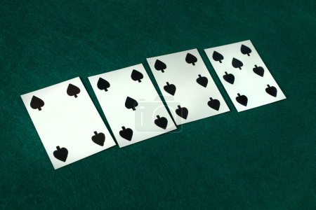 Vieille ère occidentale carte à jouer sur la table de jeu verte. 4, 5, 6, 7 de pique.