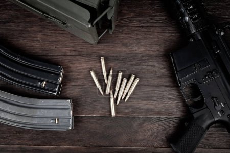 Gewehr und Munition mit Magazin auf Holztischhintergrund