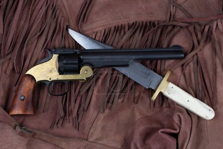 Old West Revolver with bowie knife on leather jacket background