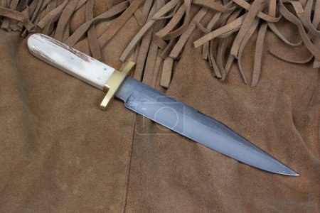Old west bowie knife on leather jacket background