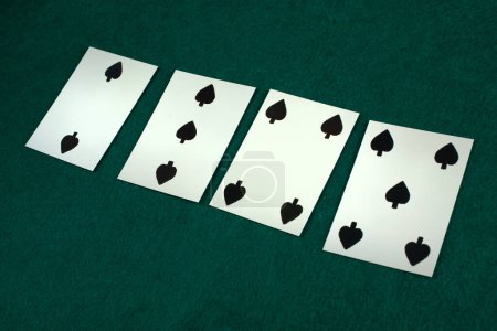 Old west era playing card on green gambling table. 2, 3, 4, 5 of spades.