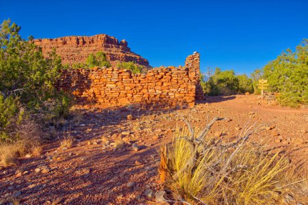 The ruins of a Mining Camp on Horseshoe Mesa at the Grand Canyon. The ridge in the background is the center of Horseshoe Mesa. A sign on the right marks 2 separate trails. One trail leads to a campsite while the other leads to public toilets.