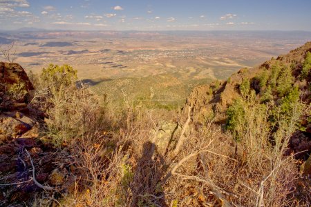 Téléchargez les photos : Vue de la vallée du Verde depuis la fin du sentier North Mingus sur le mont Mingus près de Jérôme, Arizona, dans la forêt nationale de Prescott. La ville au loin est Cottonwood avec les rochers rouges de Sedona à l'horizon. - en image libre de droit