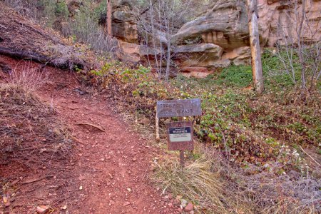 A rusty metal sign put up by the National Forest Service marking the start of the Sterling Pass Trail north of Sedona Arizona.