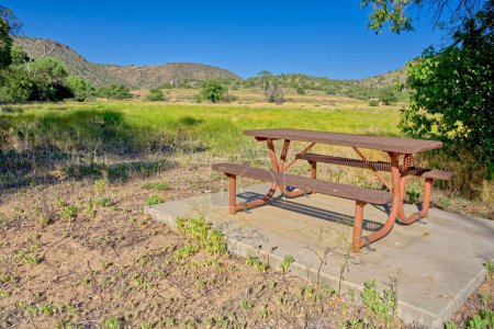 Ein Picknicktisch aus Stahl am Waldrand der historischen Stewart Ranch im Upper Verde River Wildlife Area in der Nähe von Paulden AZ.