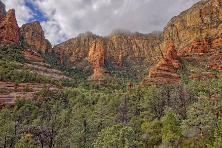 Clouds rolling in across the high cliffs at the end of the box canyon known as Wilson Canyon in Sedona Arizona.