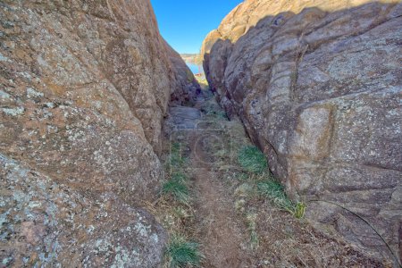 Ein schmaler Pfad zwischen Granitwänden, der den Beginn des Red Bridge Trail am Willow Lake in Prescott Arizona markiert.