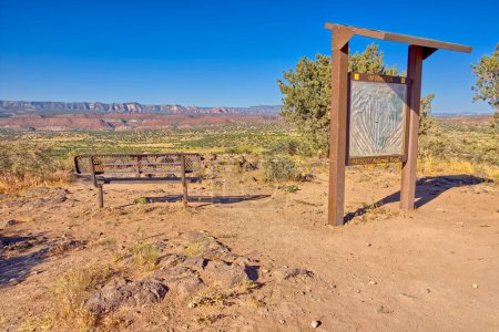An overlook sitting bench with information sign for the Upper Verde River Watershed near Perkinsville Arizona. The red rocks in the distance is the Sycamore Canyon Wilderness west of Sedona.