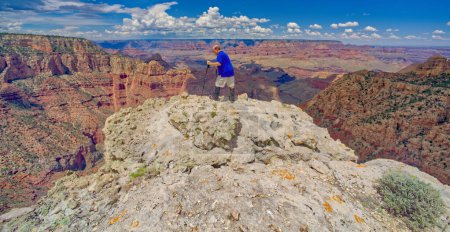 A hiker on the edge of a cliff halfway between Grandview Point and the Sinking Ship at Grand Canyon Arizona.