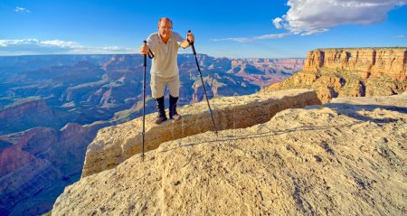 A hiker on the edge of a cliff between Moran Point and Zuni Point at Grand Canyon Arizona.
