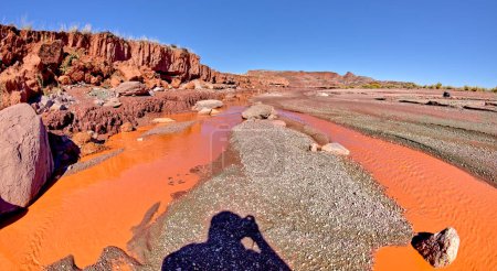 The red water of Lithodendron Wash in Petrified Forest National Park Arizona. The red color is from the bentonite clay in the surrounding hills.