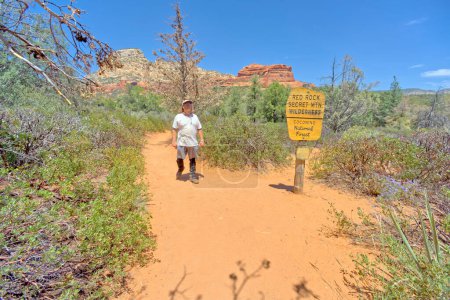 A man hiking Long Canyon Trail in Sedona Arizona. The sign marking the wilderness boundary was put up by the National Forest Service. No property release is needed.