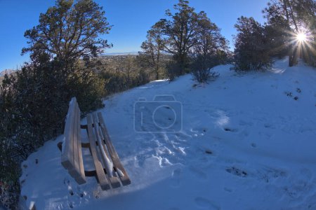 View from the first bench along the Thumb Butte day use hiking trail in the Prescott National Forest just west of Prescott Arizona, covered in winter snow and ice.