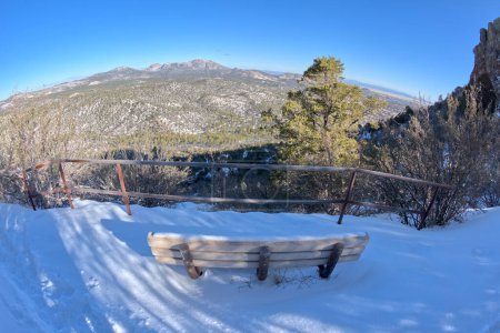 View from the second bench along the Thumb Butte day use hiking trail in the Prescott National Forest just west of Prescott Arizona, covered in winter snow and ice.