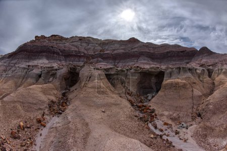 Foto de Una cueva poco profunda tallada en una pared de acantilado debajo de la Mesa Azul en el Parque Nacional Bosque Petrificado Arizona. - Imagen libre de derechos