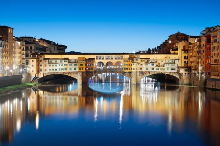 Foto de Florencia, Italia en el puente Ponte Vecchio cruzando el río Arno al atardecer. - Imagen libre de derechos