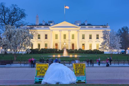 Foto de WASHINGTON DC - 8 de abril de 2015: Un manifestante acampa frente a la Casa Blanca durante la temporada de primavera al atardecer. - Imagen libre de derechos