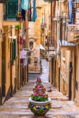 Cefalú, Sicilia, Italia Callejuelas con flores en maceta.