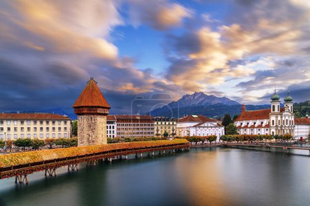 Photo for Lucern, Switzerland with the Chapel Bridge over the River Reuss with Mt. Pilatus in the distance at dusk. - Royalty Free Image