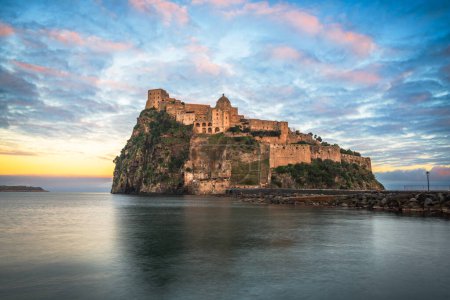 Foto de Ischia, Italia con el castillo aragonés en el Mediterráneo al atardecer. - Imagen libre de derechos