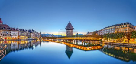 Lucerne, Switzerland with the Chapel Bridge and water tower over the River Reuss at dawn.