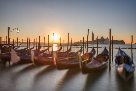 Téléchargez les photos : Longue exposition de Venise, Italie avec gondoles ancrées sur le Grand Canal au lever du soleil. - en image libre de droit