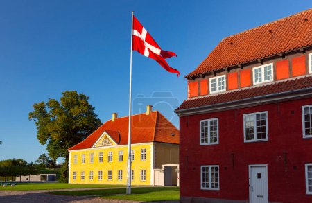 Dänische Flagge weht bei Sonnenuntergang über der Royal Barracks in Kopenhagen, Dänemark, Kronprinsessegade Park