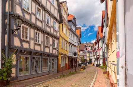 Traditional timber-framed houses line the cobblestone street leading to Marburg Castle, Germany