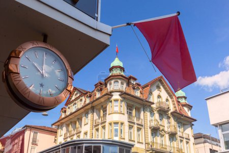 Alte Uhr und traditionelles Haus in der Altstadt von Interlaken, Schweiz