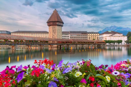 Twilight view of historic Chapel Bridge and Water Tower in Lucerne, Switzerland