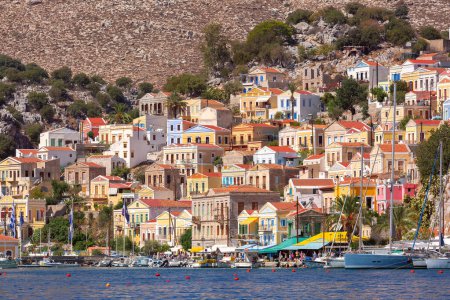 Blick auf die bunten Gebäude und den belebten Hafen auf der Insel Symi, Griechenland.